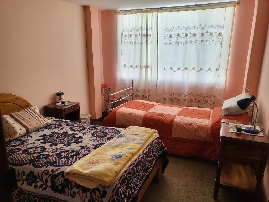 拉塔昆加Como en casa的酒店客房设有两张床和窗户。