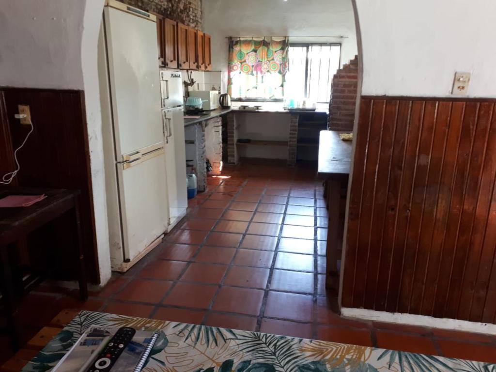 罗萨里奥Alojamiento hostel Lodeolga "La Florida"的厨房配有白色冰箱,铺有瓷砖地板。