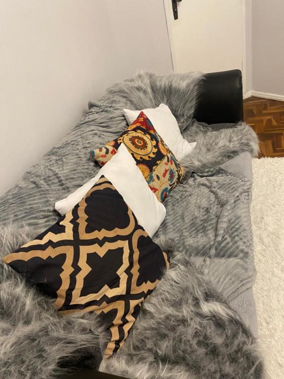 巴热Confortável Apartamento em Bagé的一张带枕头的床和灰色毯子