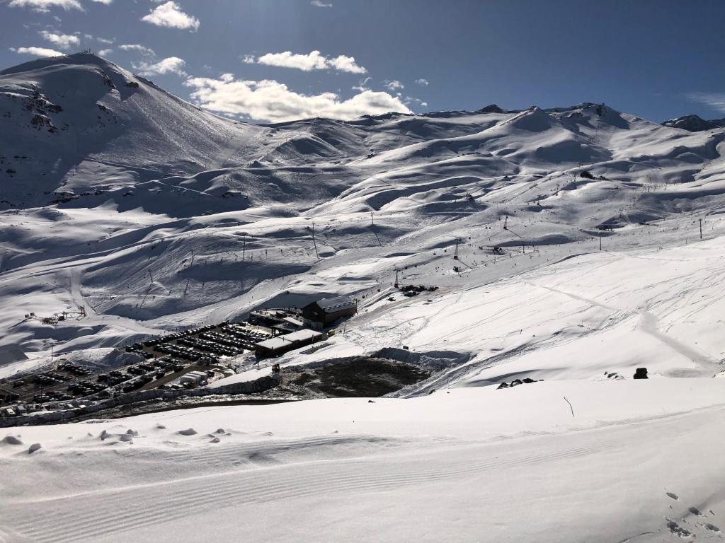 Lo BarnecheaDepartamento residencial Valle Nevado的滑雪场上一座有雪覆盖的山,有一座小镇