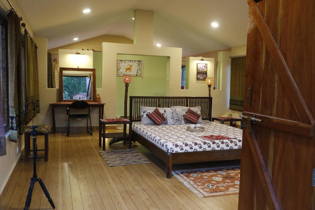塔拉Atulya Kanchi Camp Bandhavgarh的一间卧室配有一张床和一张书桌