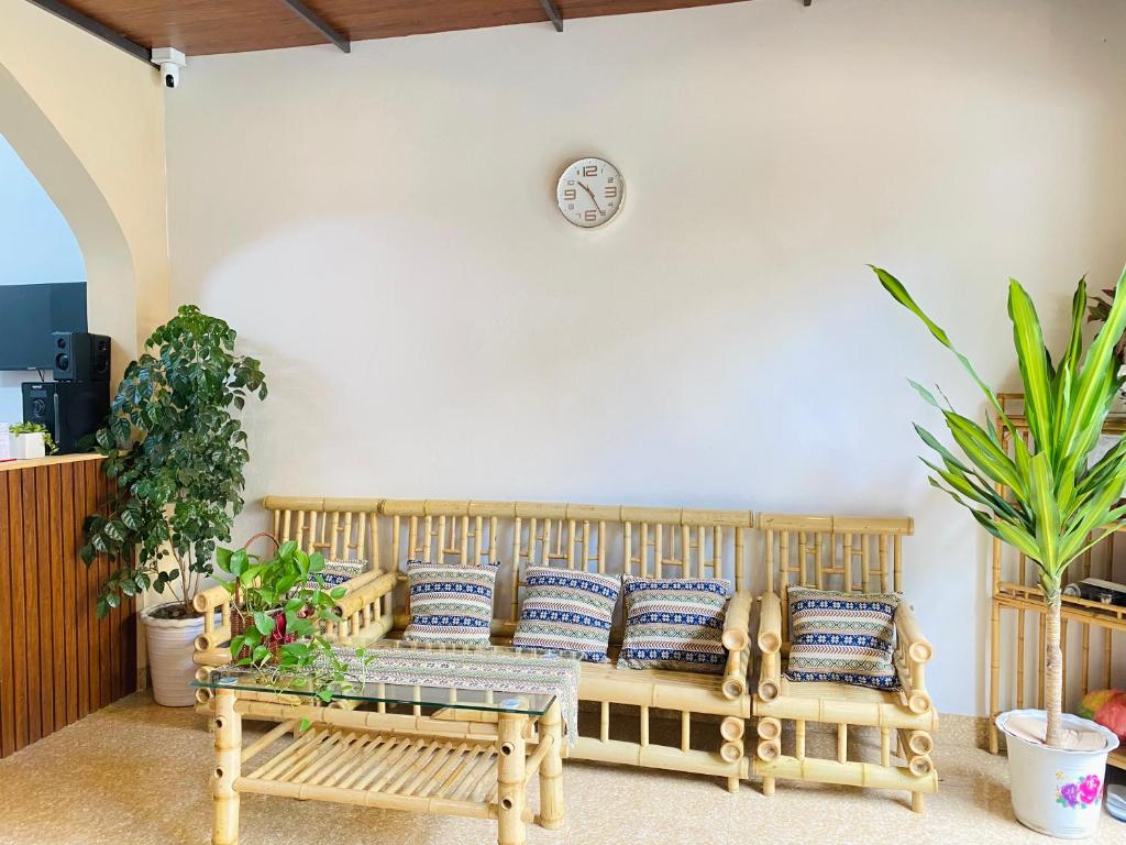 高平DH Homestay Cao Bằng的客厅配有沙发和墙上的时钟