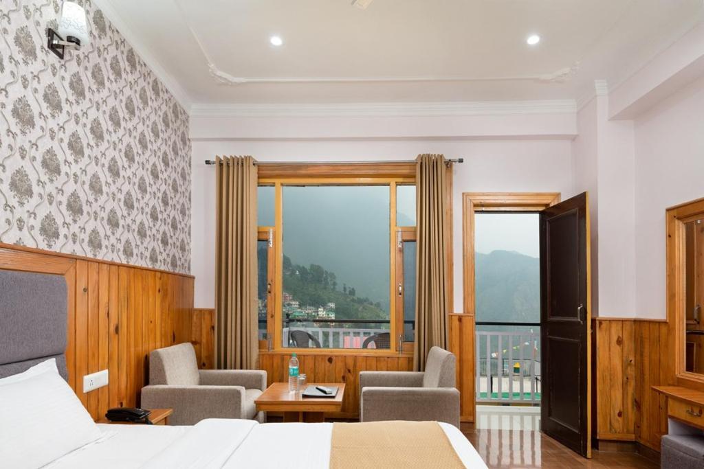达兰萨拉Vella Marina Group of hotels Mcleodgunj的酒店客房设有一张床和一个阳台。