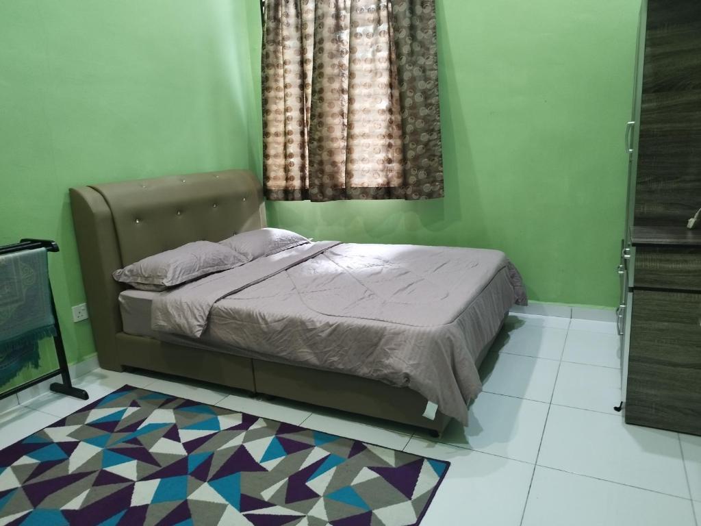 甲抛峇底Nurul Homestay的一间卧室设有一张床,铺有色彩缤纷的地板。