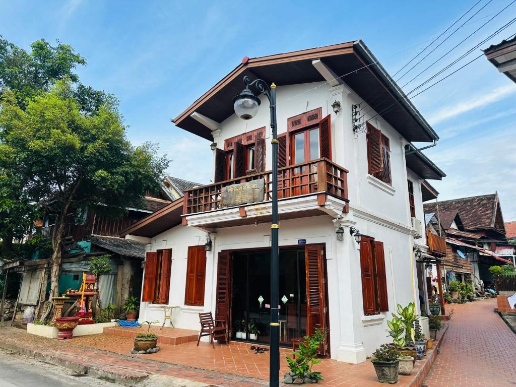 琅勃拉邦Villa Phonethip Mekong Riverside的街道上带阳台的白色房屋