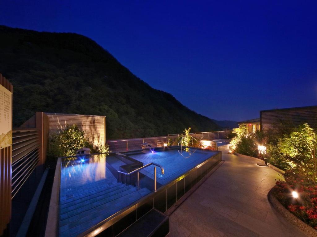 日光鬼怒川温泉酒店的夜间在建筑物屋顶上的游泳池