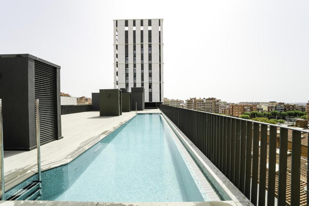 科尔内拉德罗布雷加特Sunsets and the pool in Barcelona的建筑物屋顶上的游泳池