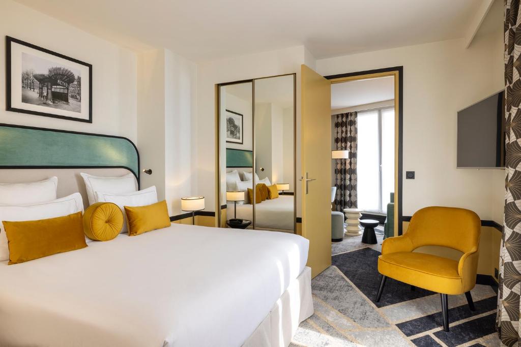 巴黎Hôtel Aiglon的一间卧室配有一张大床和一张黄色椅子