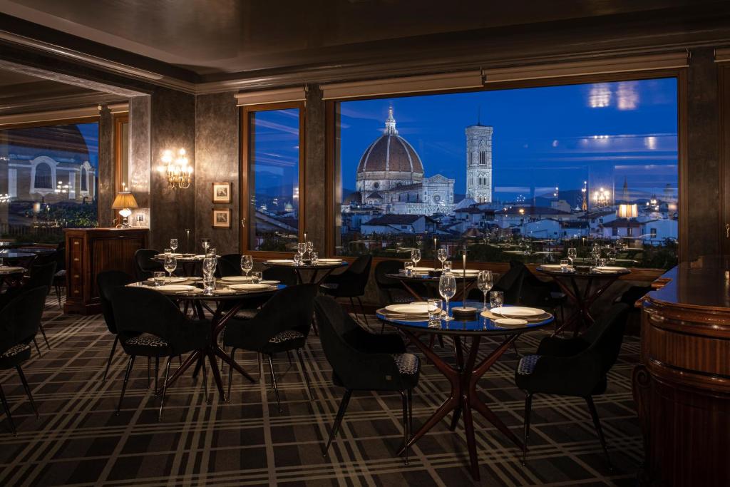 佛罗伦萨巴利奥尼大酒店的一间带桌椅的市景餐厅