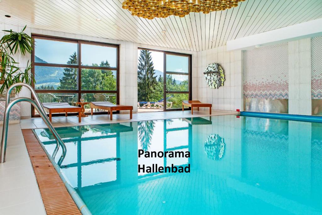 巴德哥依斯恩Appartementhaus Dachsteinblick mit Indoorpool und Sauna的游泳池位于酒店带大窗户的客房