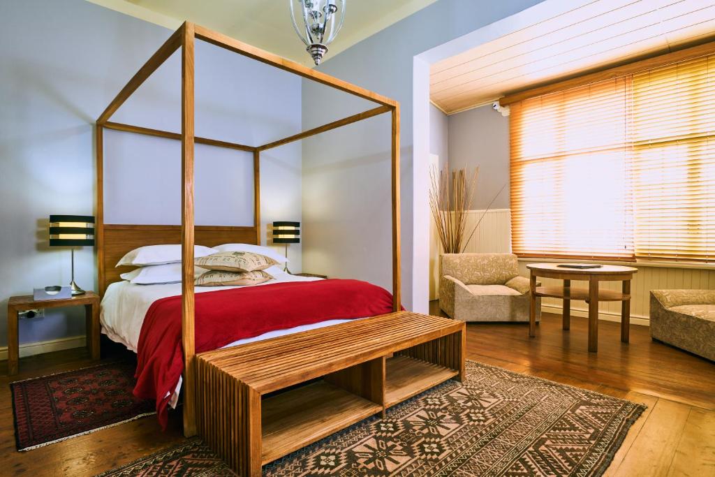 斯瓦科普蒙德Villa Margherita的一间卧室配有一张四柱床和红毯