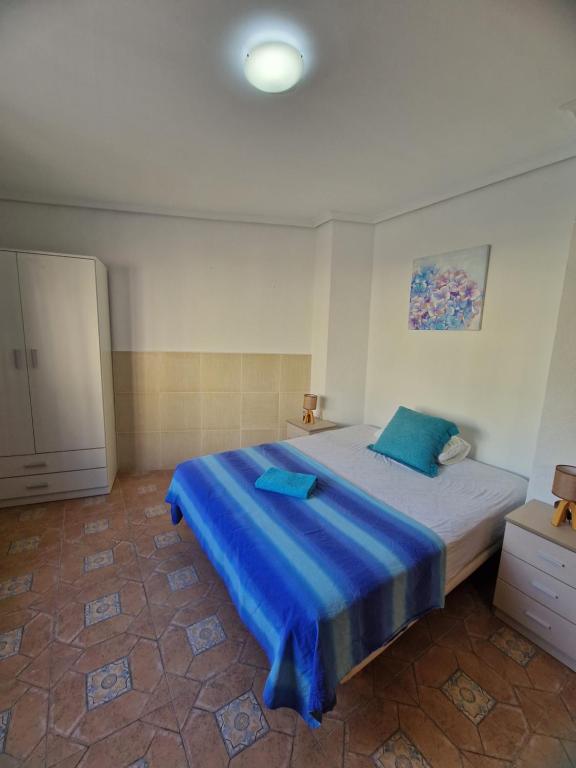 阿尔博拉亚Casa Alboraya Valencia的一间卧室配有一张带蓝色床单的大床