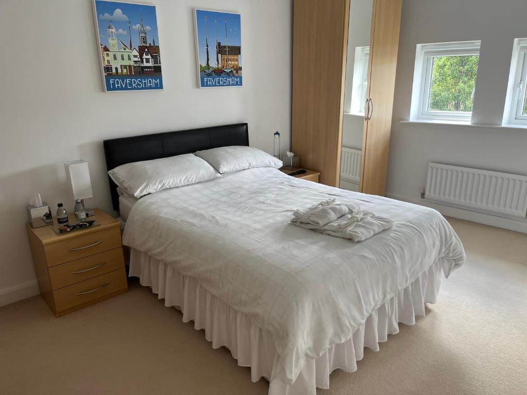 彼得伯勒Hampton Vale, Peterborough Lakeside Large Double bedroom with own bathroom的一间卧室设有一张大床、一个梳妆台和两个窗户。