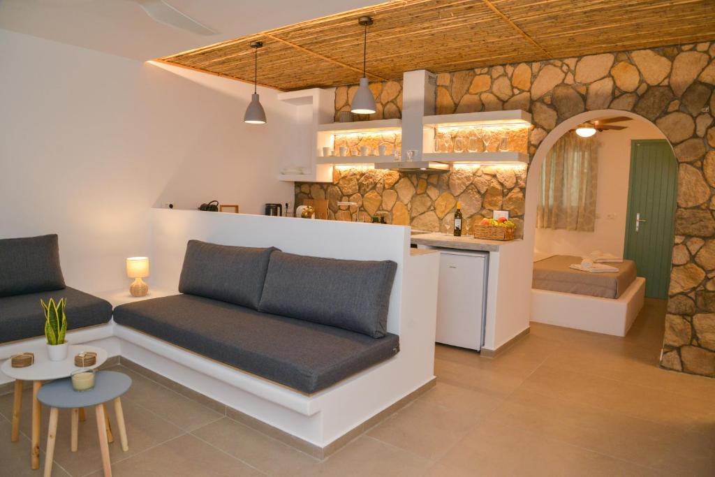 特里皮蒂Mylopetra Milos Suites的带沙发的客厅和厨房