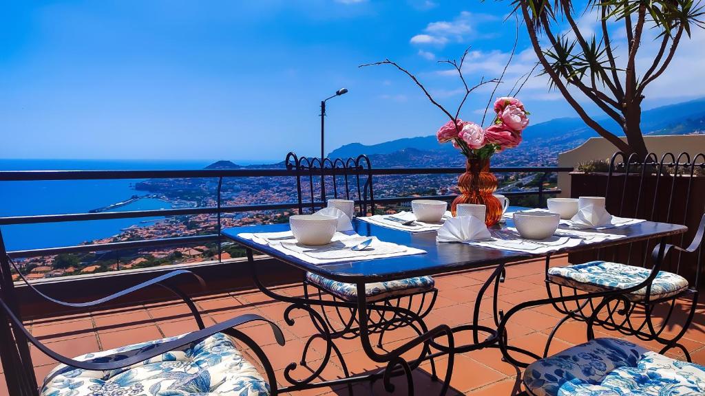 丰沙尔Casa Gina, with views to Funchal Bay的美景阳台配有桌椅