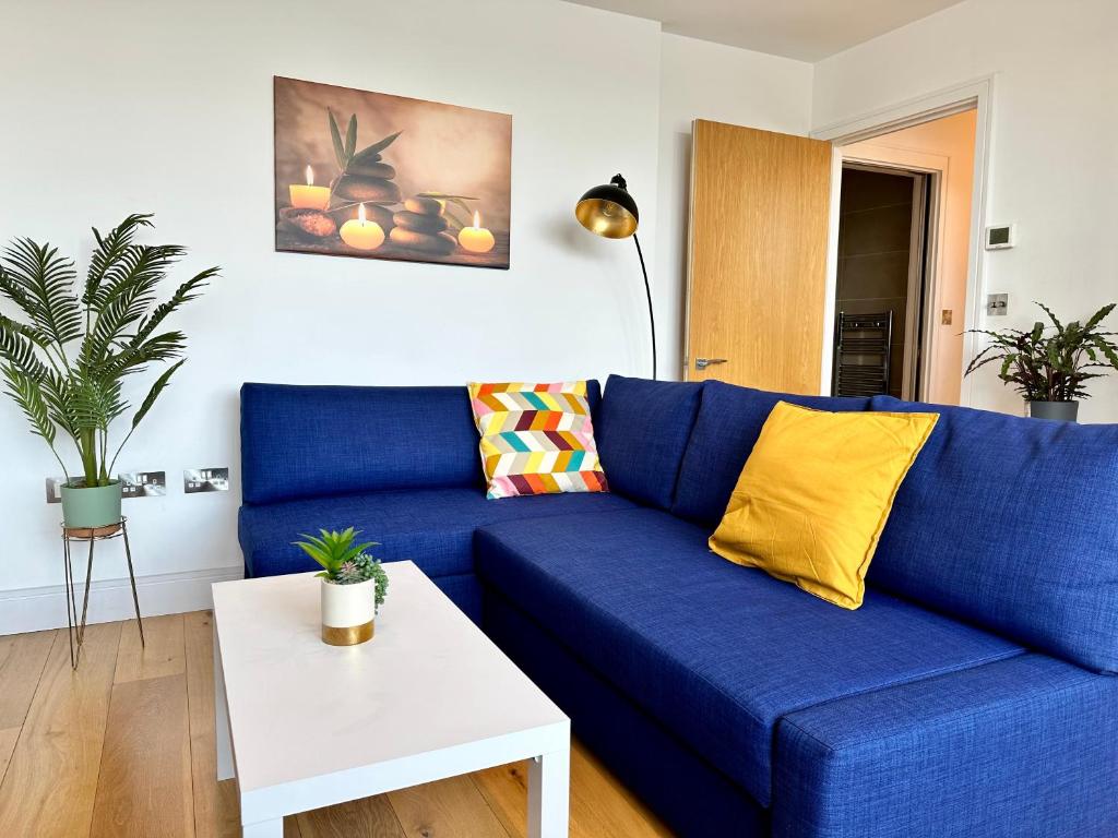 海华德希思Cosy Apartment Haywards Heath的客厅配有一张蓝色的沙发,配有一张桌子