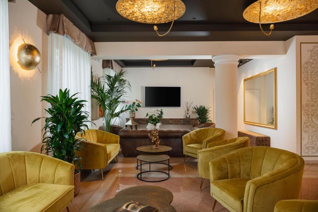 米兰马瑞提那玛赞提酒店的大堂设有黄色椅子、沙发和电视。