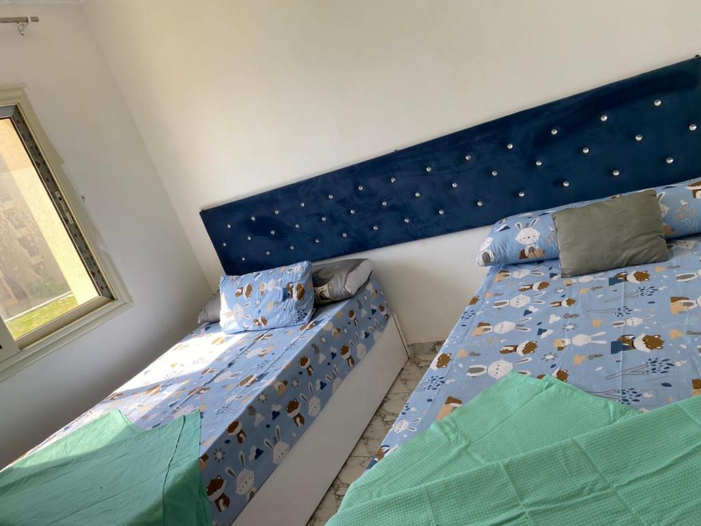 马特鲁港مرسى مطروح的一间卧室配有两张单人床和蓝色床头板