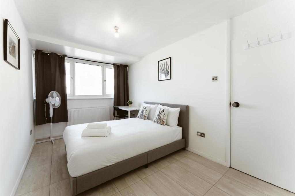 伦敦Stratford Cosy rooms - 17的白色的卧室设有床和窗户