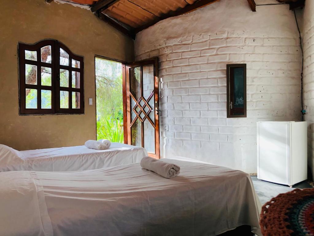 圣若热岛Espaço Shanti - Chalés的一间卧室配有两张床和一台冰箱