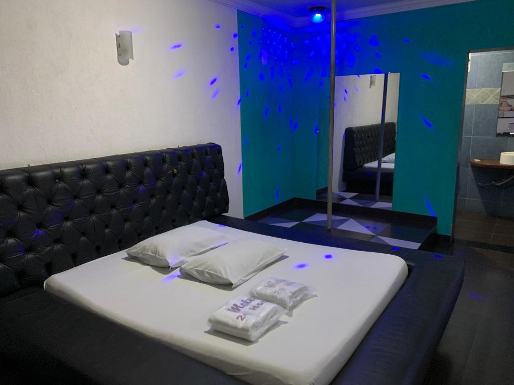 孔塔任24 Horas Motel Jaguar Contagem的一间卧室配有一张床,上面有两条毛巾