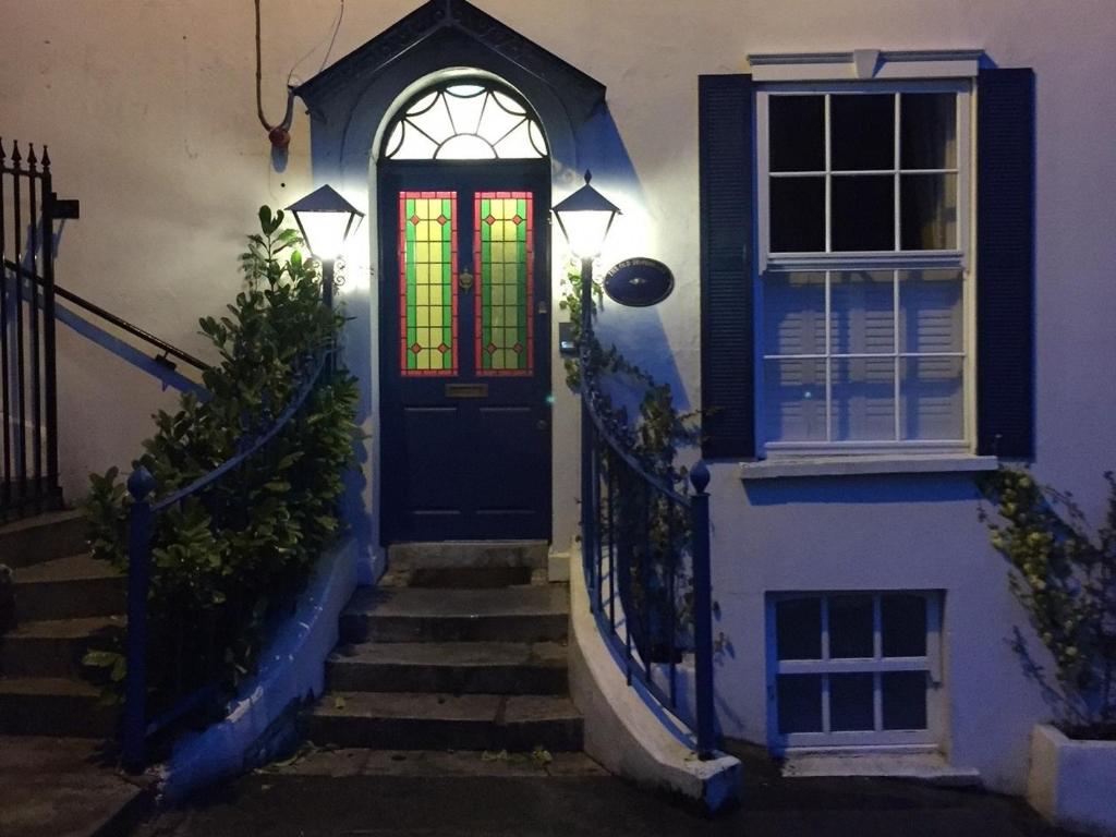 金塞尔The Old Dispensary的一座带彩色玻璃窗的蓝色门的房子