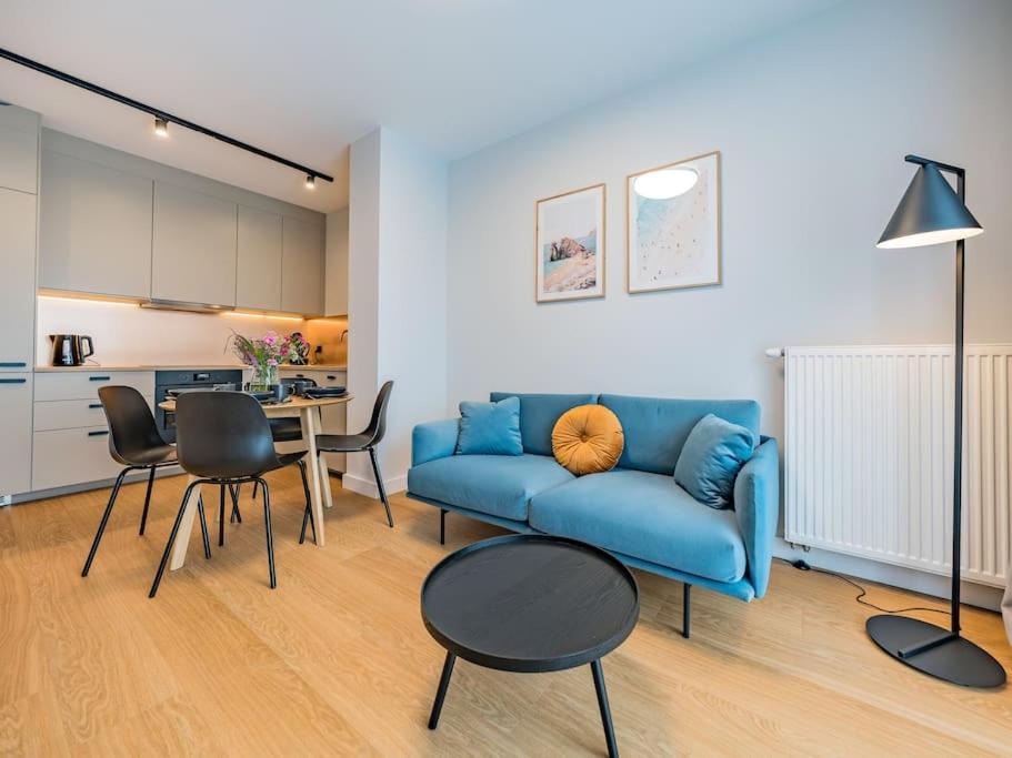 格但斯克Hello Apartments RIO with private parking的客厅配有蓝色的沙发和桌子