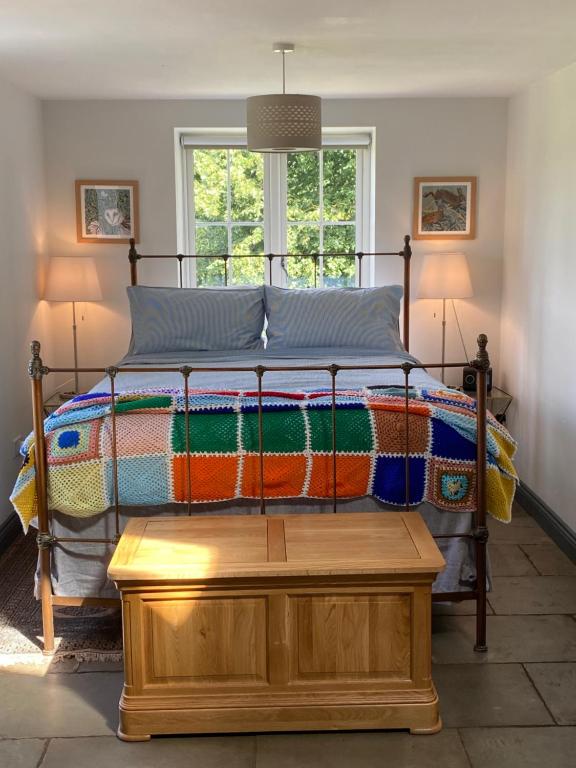 Worfe View Cottage的一间卧室配有一张带彩色毯子的床