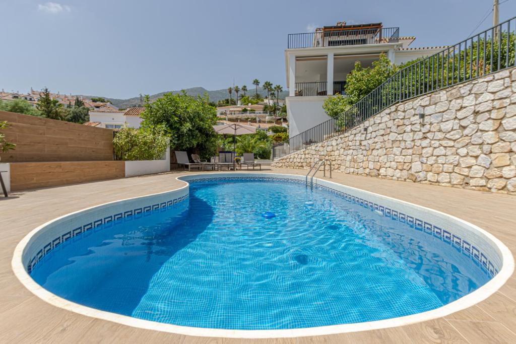 贝纳尔马德纳Luxury Top Villa Alhambra Pool close to Sea and Centre的大楼前的蓝色海水游泳池