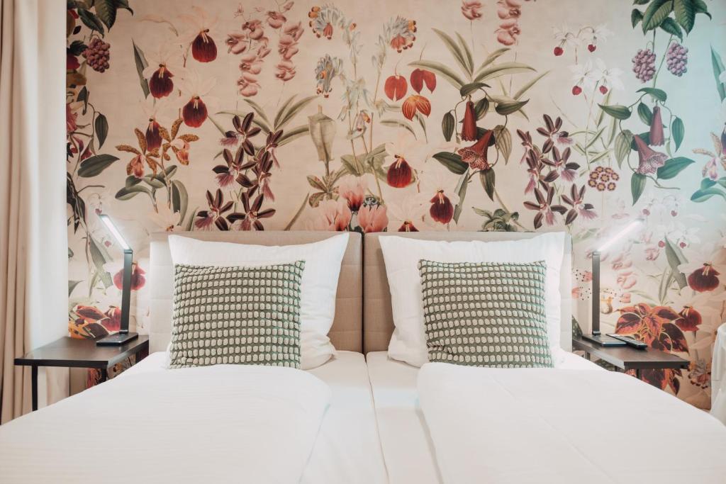 富尔达House of Blooms的一间卧室配有两张带花卉壁纸的床