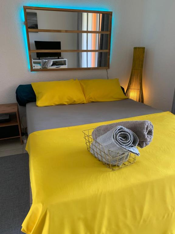 卡宴Le nid du Kikiwi , refuge relaxant avec jardin的一张黄色床单和一篮子的床