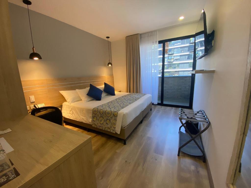 麦德林EcoHub Hotel Medellin的酒店客房设有一张床和一个大窗户