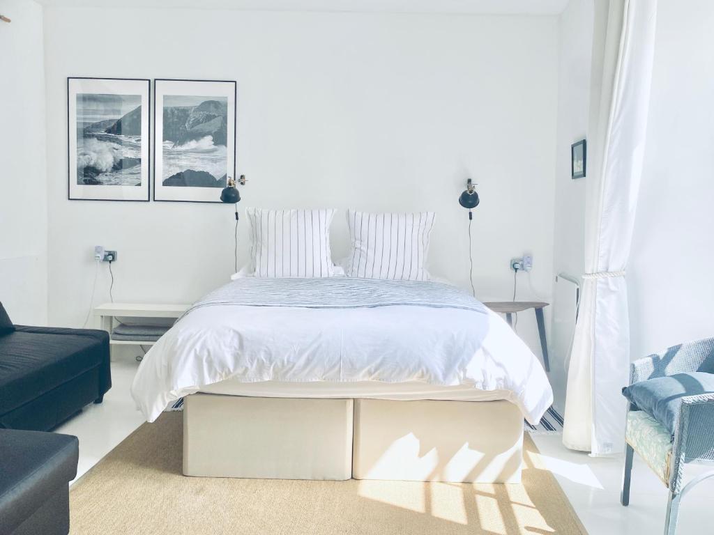 卡迪根The Art Room Apartment的白色卧室配有床和蓝色沙发