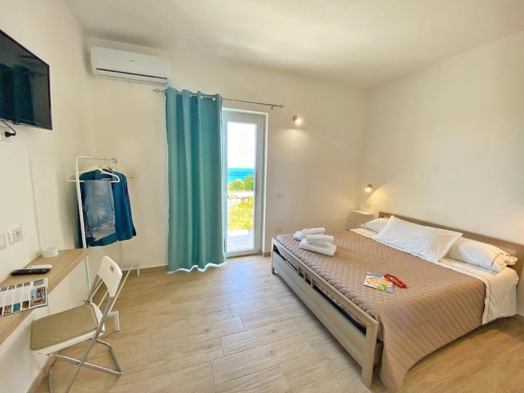 特罗佩阿Campus Dei - Tropea Rooms的一间卧室设有一张床和一个大窗户