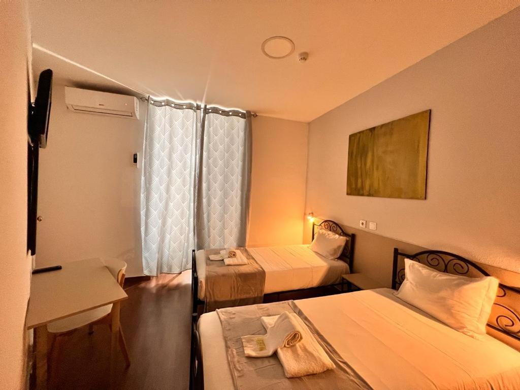 里斯本佩绍诺瓦戈雅酒店的酒店客房设有两张床和一张桌子。