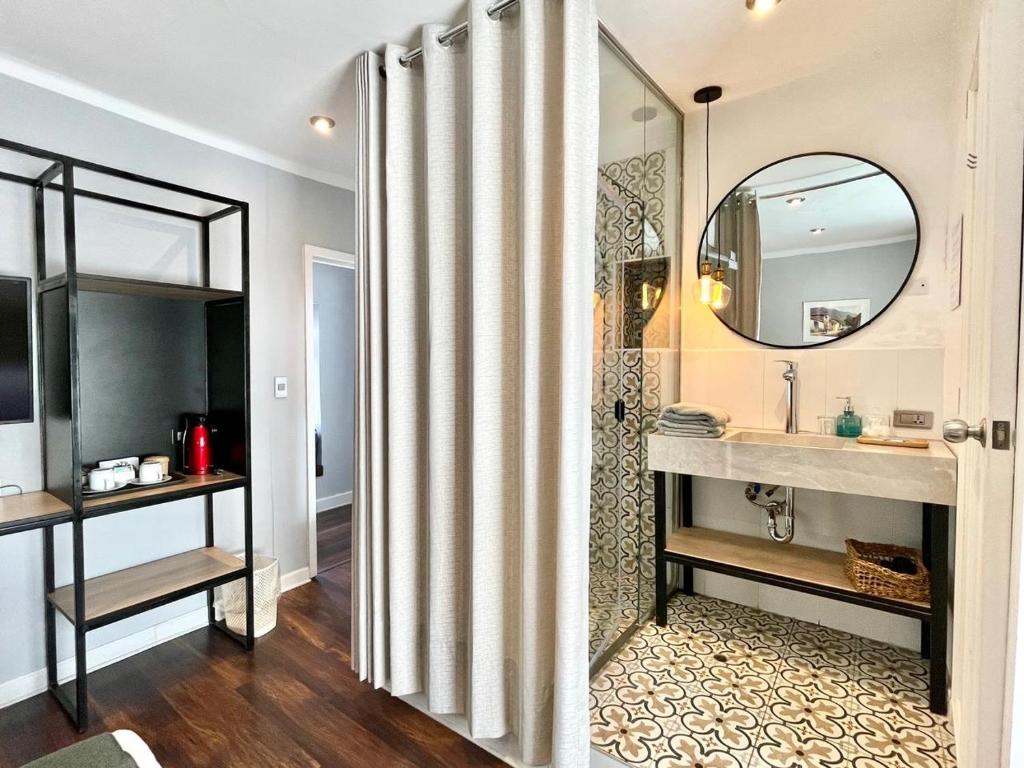 库斯科Casa Montes San Blas的浴室配有盥洗盆和带镜子的淋浴