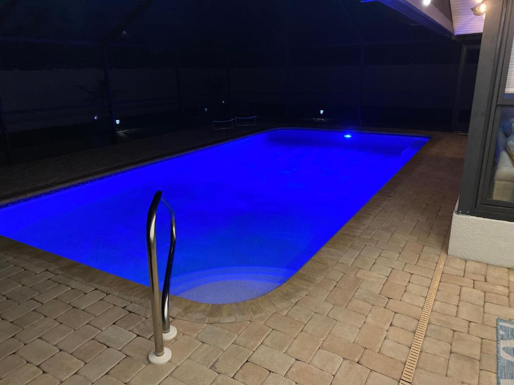 威尼斯Venice Dream Vacations, Centrally Located, Just Waiting For You的夜晚在房子里的一个蓝色游泳池