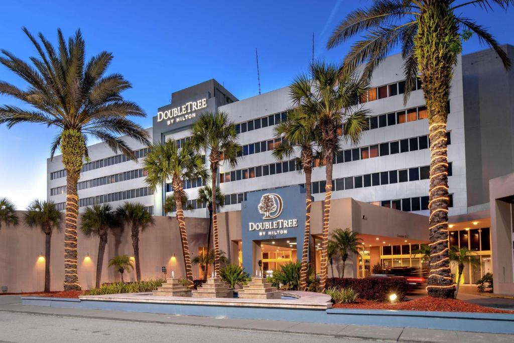 杰克逊维尔杰克逊维尔机场希尔顿逸林酒店的前面有棕榈树的酒店
