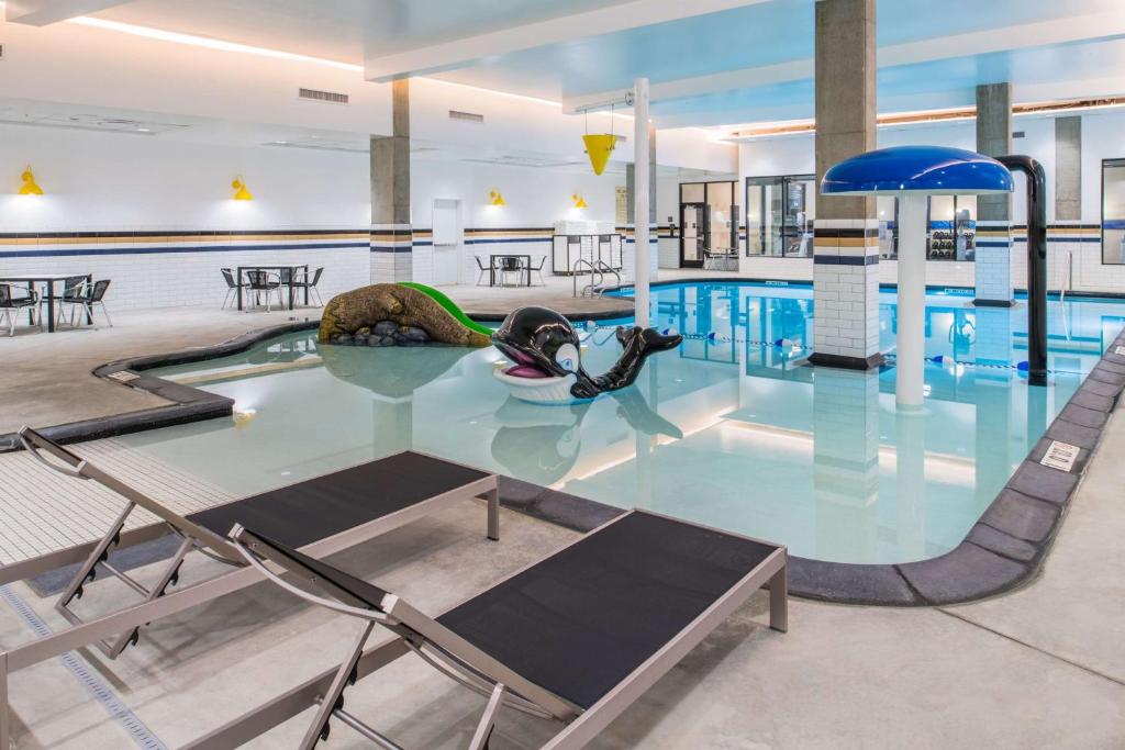 波特兰波特兰珍珠区希尔顿汉普顿套房酒店的一个带椅子和桌子的大型游泳池