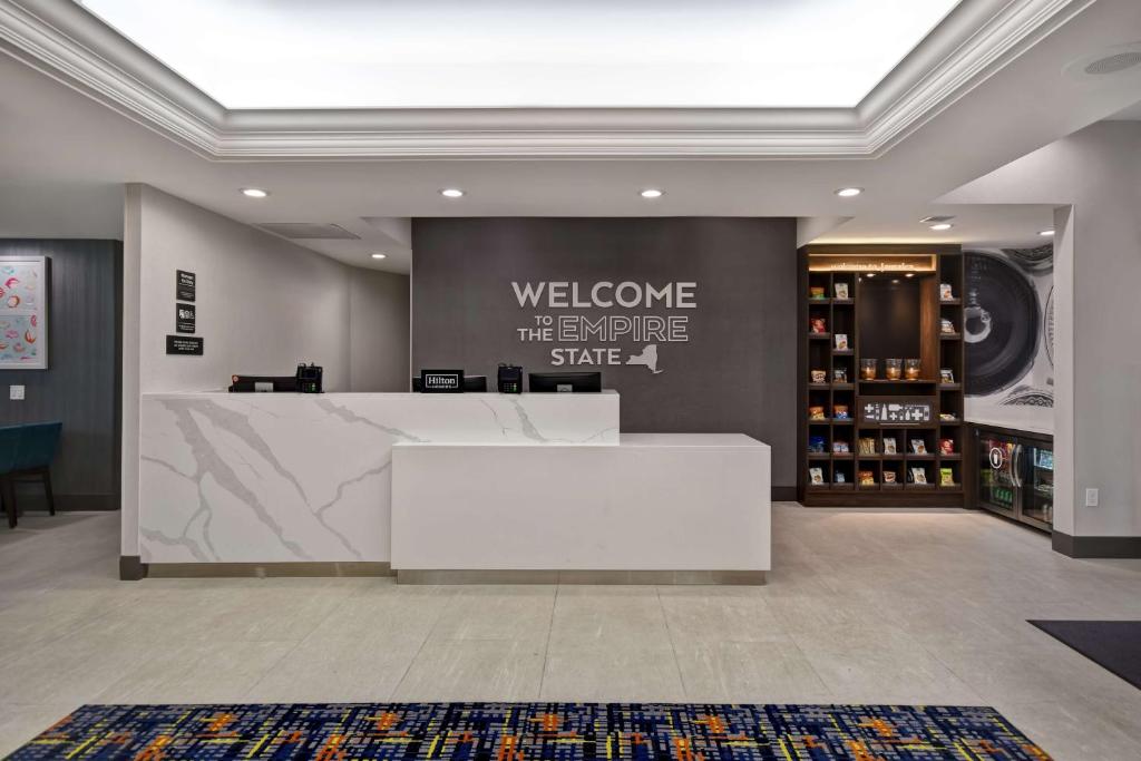 皇后区Hampton Inn NY-JFK的一间房间中间有白色柜台的商店