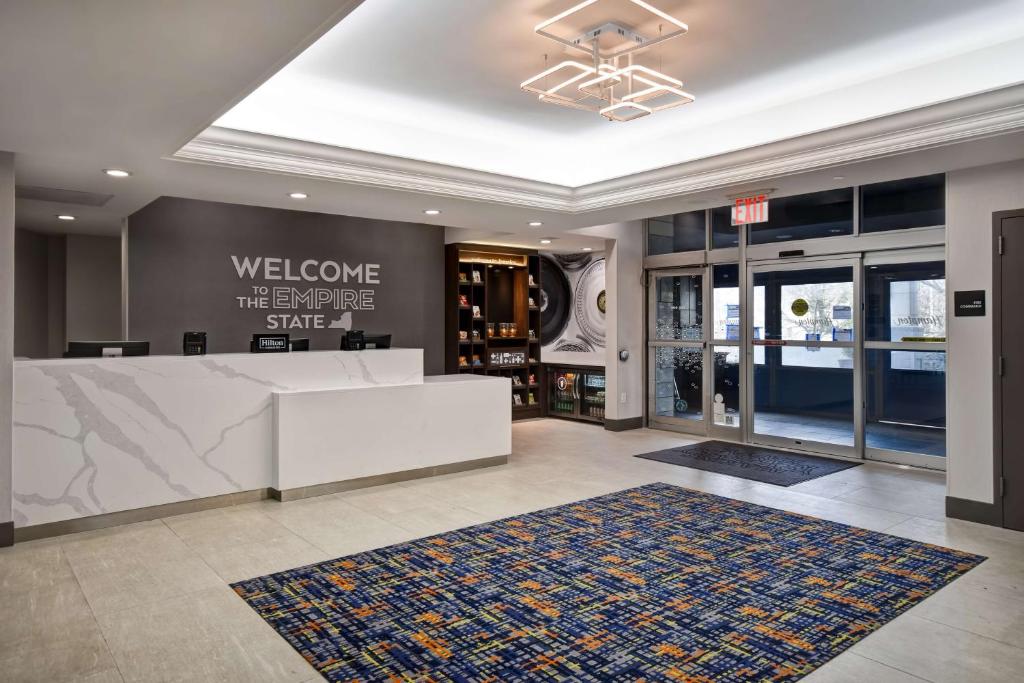 皇后区Hampton Inn NY-JFK的大堂设有白色的前台和地毯