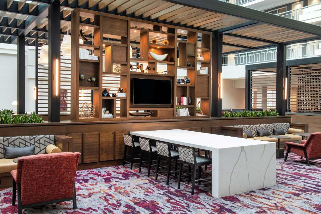 核桃溪Embassy Suites by Hilton Walnut Creek的大堂设有桌椅和电视。