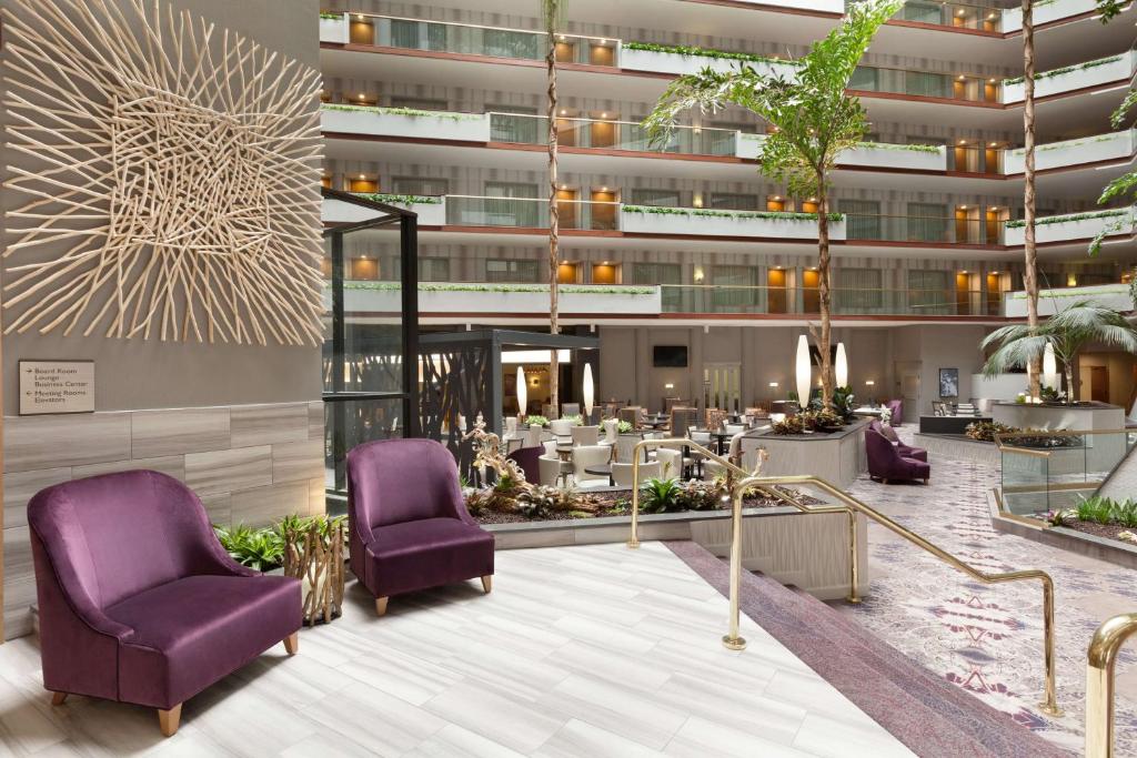 尔湾Embassy Suites by Hilton Irvine Orange County Airport的大堂,设有紫色椅子和桌子