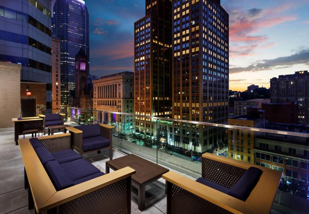 匹兹堡Joinery Hotel Pittsburgh, Curio Collection by Hilton的大楼内带桌椅的屋顶露台