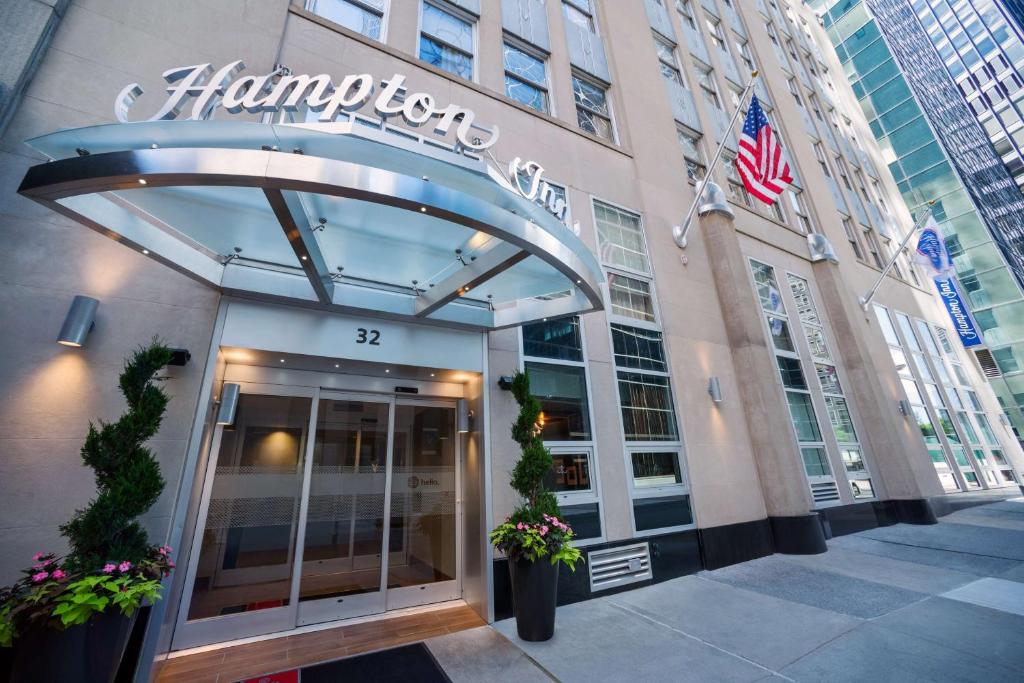 纽约曼哈顿/闹市区汉普顿旅馆 - 金融区的带有美国国旗的汉普顿酒店的入口