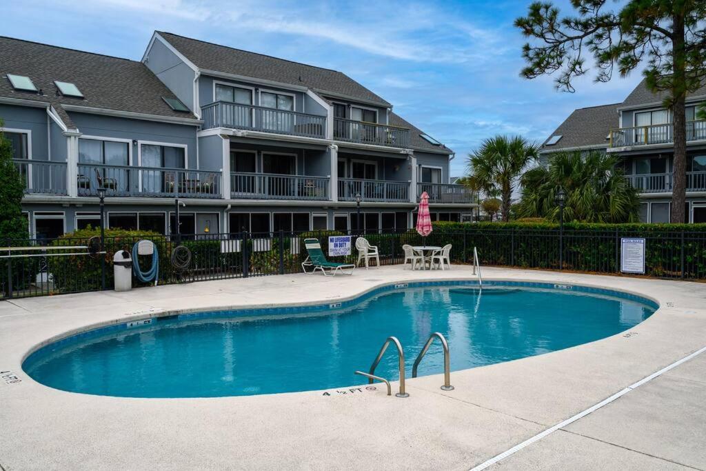 默特尔比奇Poolside Condo in Surfside Beach的公寓大楼前的游泳池