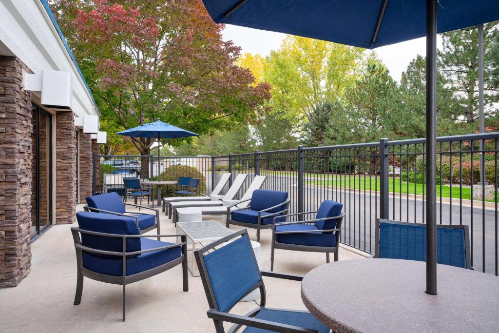 拉夫兰洛夫兰希尔顿恒庭酒店的庭院配有桌椅和遮阳伞。