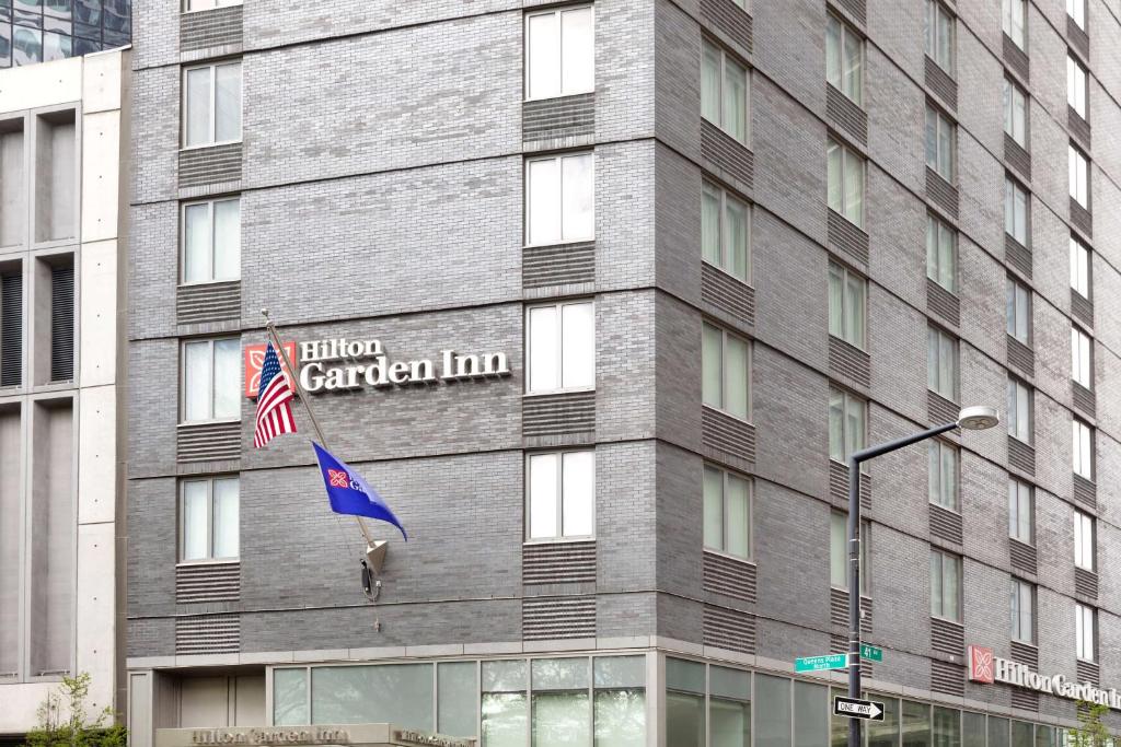 皇后区Hilton Garden Inn Long Island City的一面有旗帜的建筑