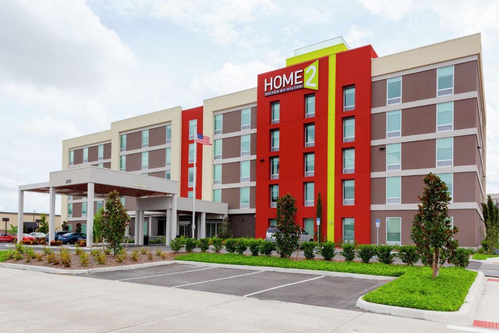 奥兰多Home2 Suites By Hilton Orlando South Park的上面有家庭标志的酒店大楼