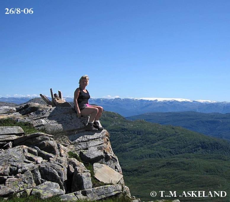 努尔黑姆松Panoramahytte的坐在岩石山顶上的女人